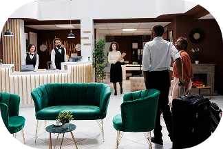 Otel misafirleri, ön büro personelinin yardımıyla check-in sürecinde resepsiyon masasına varıyor.