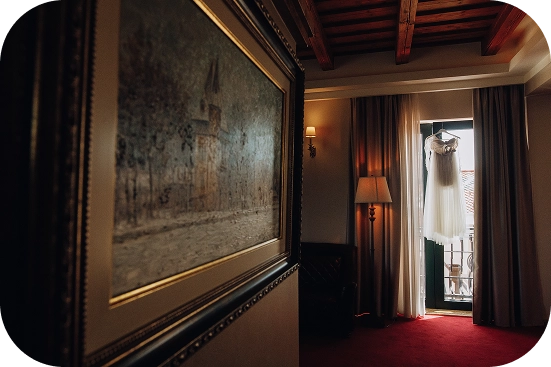 Düğün töreni için hazırlanmış zarif bir otel odasında asılı gelinlik.